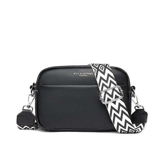 Lumina Wear Bella compact black leather shoulder handbag with sleek design and gold-tone hardware.